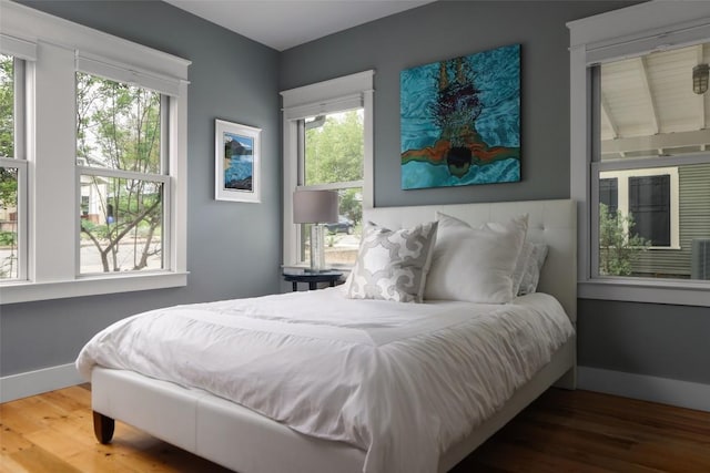606 E 42nd St, Austin, TX 78751 - bedroom with wood finished floors, baseboards, and multiple windows