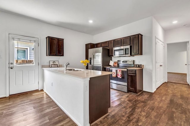 771 Circle Way, Jarrell, TX 76537 - kitchen featuring appliances with stainless steel finishes, dark brown cabinetry, dark wood-style flooring, light countertops, and a peninsula