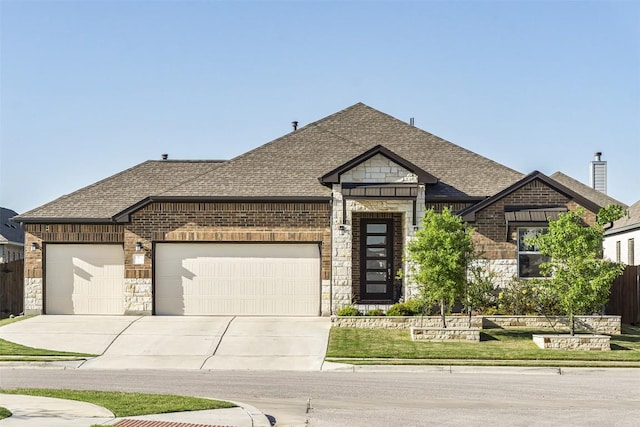 french country style house with a shingled roof, a garage, concrete driveway, and brick siding