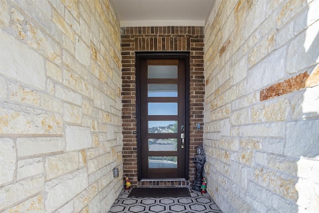 property entrance with brick siding and stone siding