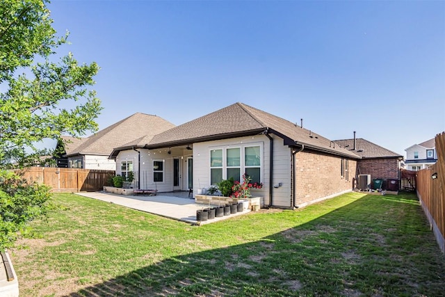 back of property featuring a fenced backyard, a patio, a lawn, and roof with shingles
