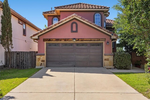 6220 Seville Dr, Austin, TX 78724 - mediterranean / spanish-style home with a tiled roof, stone siding, a garage, fence, and driveway