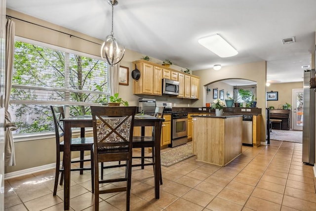6220 Seville Dr, Austin, TX 78724 - kitchen with light brown cabinetry, visible vents, appliances with stainless steel finishes, dark countertops, and plenty of natural light