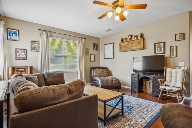 6220 Seville Dr, Austin, TX 78724 - living room featuring visible vents, baseboards, a ceiling fan, a fireplace, and wood finished floors