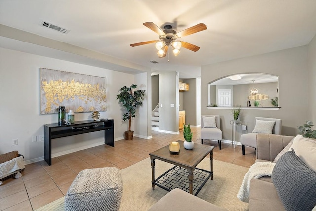 6220 Seville Dr, Austin, TX 78724 - living area with light tile patterned floors, stairway, a ceiling fan, and arched walkways