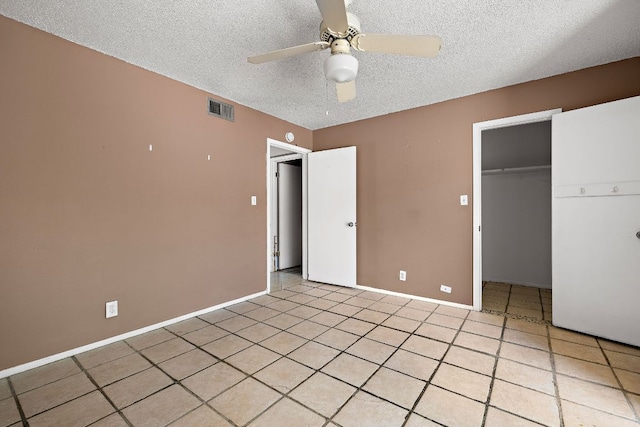 500 E Riverside Dr Unit 146, Austin, TX 78704 - unfurnished bedroom with a textured ceiling, a closet, light tile patterned floors, a ceiling fan, and a spacious closet
