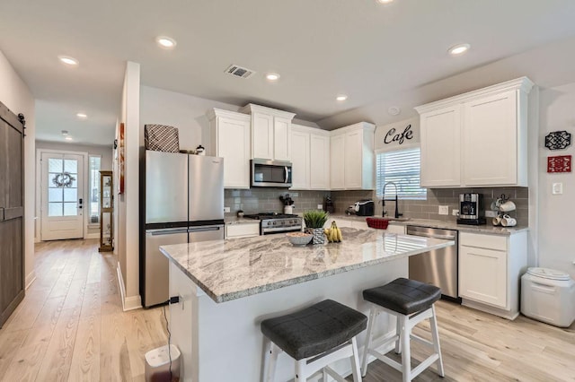 116 Angel Oak Way, San Marcos, TX 78666 - kitchen featuring visible vents, white cabinets, appliances with stainless steel finishes, and light stone countertops