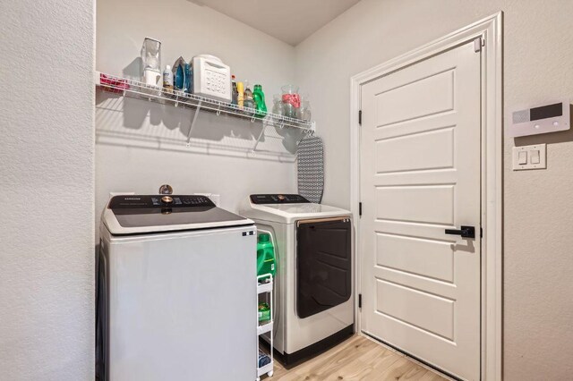 116 Angel Oak Way, San Marcos, TX 78666 - laundry room with light wood finished floors, laundry area, and washing machine and clothes dryer