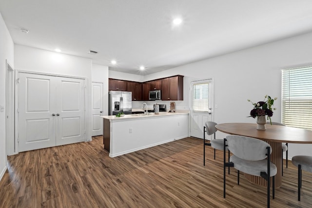 3313 Lodgepole Dr, Austin, TX 78744 - kitchen with a peninsula, appliances with stainless steel finishes, dark wood finished floors, and visible vents