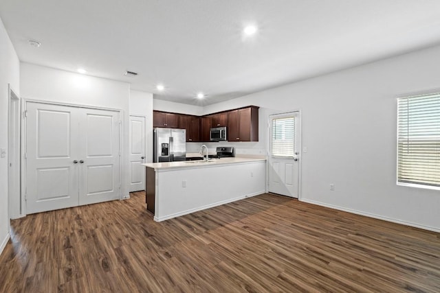 3313 Lodgepole Dr, Austin, TX 78744 - kitchen featuring a peninsula, light countertops, visible vents, dark wood finished floors, and appliances with stainless steel finishes