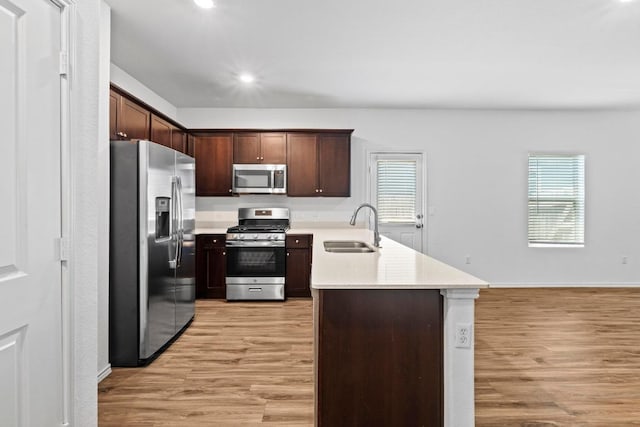 3313 Lodgepole Dr, Austin, TX 78744 - kitchen with light wood-style flooring, a peninsula, a sink, and stainless steel appliances