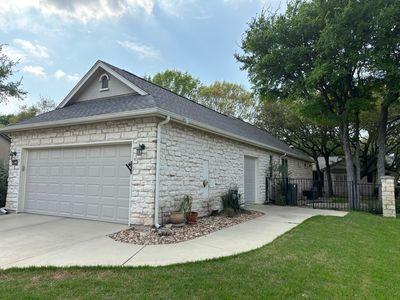 122 Camp Dr, Georgetown, TX 78633 - view of property exterior featuring an attached garage, stone siding, and driveway