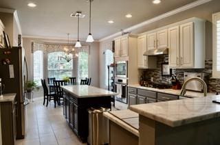 122 Camp Dr, Georgetown, TX 78633 - kitchen with ornamental molding, freestanding refrigerator, recessed lighting, a center island, and decorative light fixtures