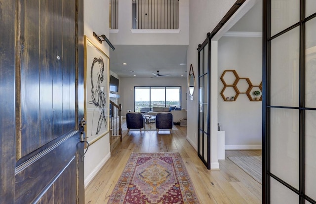 304 Ashburn Cv, Austin, TX 78738 - foyer entrance featuring a barn door, light wood finished floors, a ceiling fan, baseboards, and recessed lighting