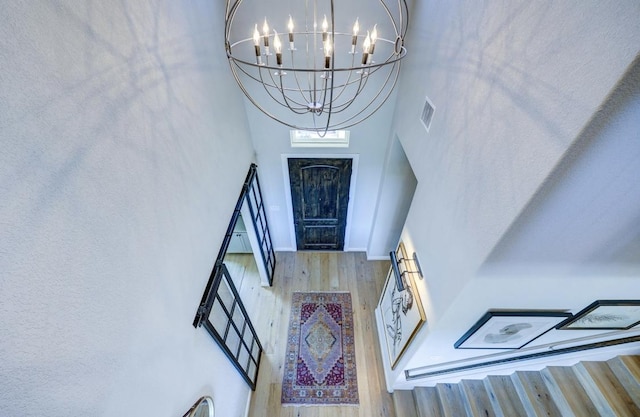 304 Ashburn Cv, Austin, TX 78738 - foyer with wood finished floors, a chandelier, a towering ceiling, and baseboards