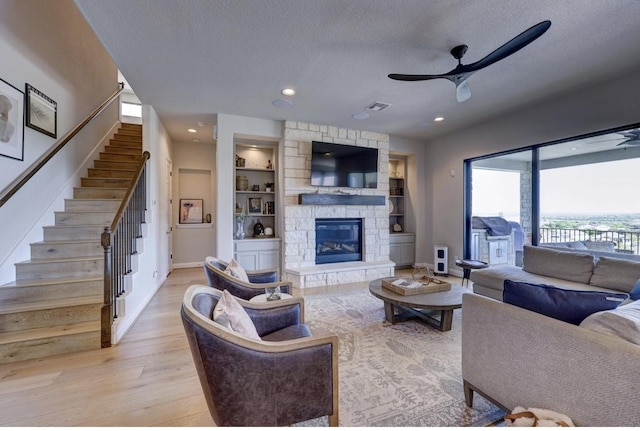 304 Ashburn Cv, Austin, TX 78738 - living area with a ceiling fan, a textured ceiling, stairway, light wood-style floors, and baseboards