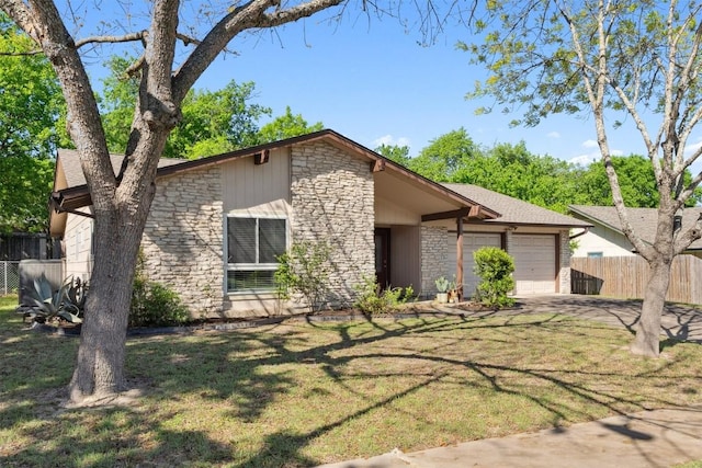 mid-century modern home featuring an attached garage, fence, stone siding, and a front yard