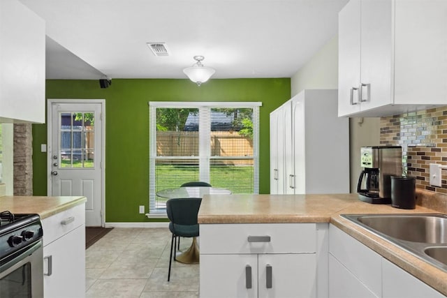 1405 Meadowmear Dr, Austin, TX 78753 - kitchen featuring white cabinets, decorative backsplash, light countertops, and stainless steel gas stove