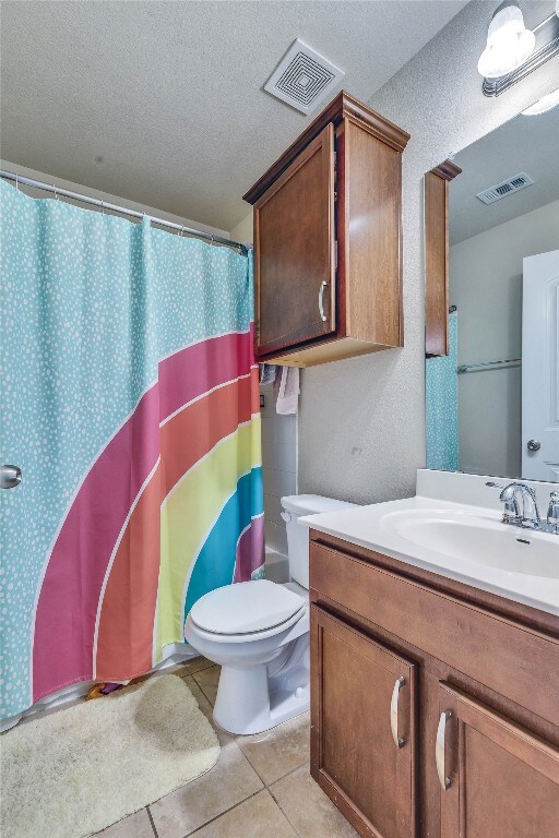 1012 Lost Pines Ln, Cedar Park, TX 78613 - bathroom with vanity, toilet, a textured ceiling, tile patterned floors, and a shower with shower curtain