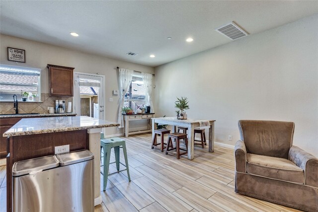 1012 Lost Pines Ln, Cedar Park, TX 78613 - kitchen with a sink, recessed lighting, light stone counters, baseboards, and light wood-style flooring