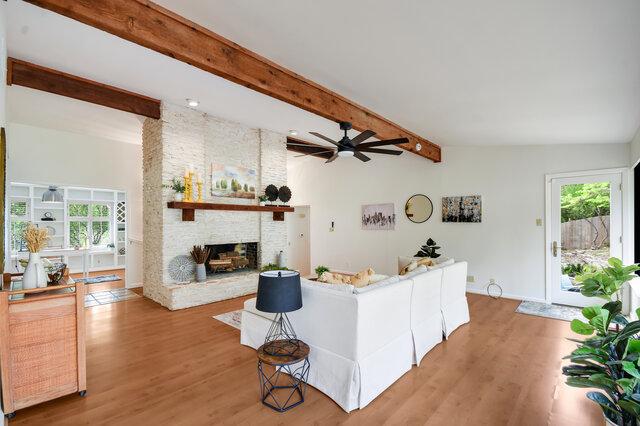 6304 Whitemarsh Valley Walk, Austin, TX 78746 - living room with a ceiling fan, beamed ceiling, light wood finished floors, and a fireplace