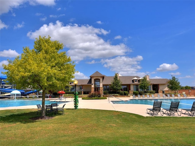 pool with a lawn, fence, and a patio area