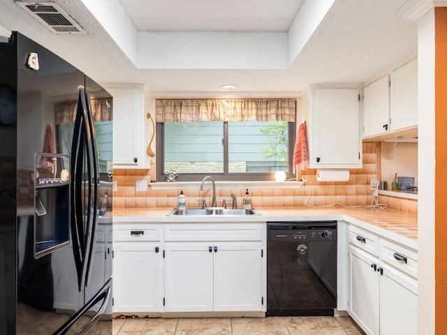 kitchen with visible vents, white cabinets, a sink, light countertops, and black appliances
