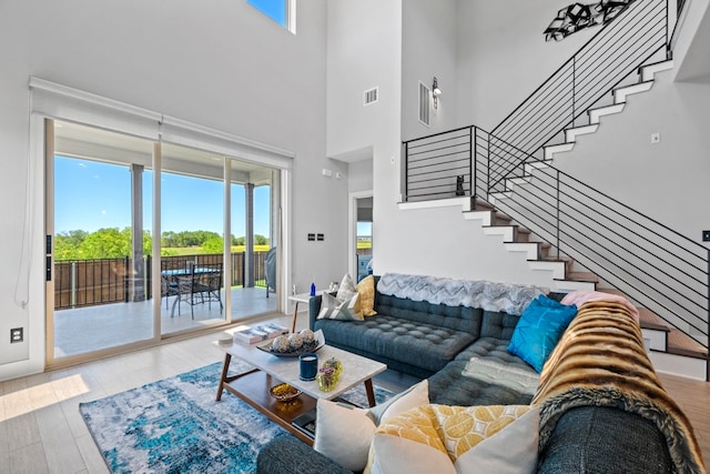 132 Alba Ave, San Marcos, TX 78666 - living room with wood finished floors, visible vents, a high ceiling, and stairs