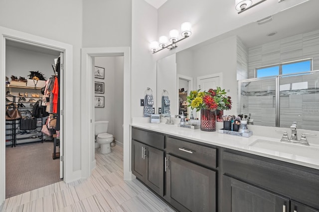 132 Alba Ave, San Marcos, TX 78666 - bathroom with a sink, double vanity, toilet, a shower stall, and a walk in closet