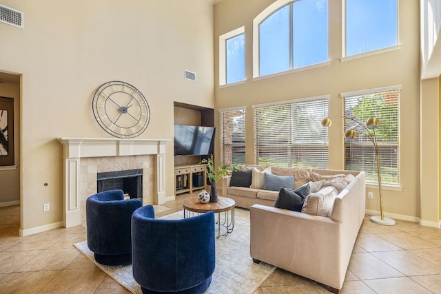 1812 Buffalo Thunder, Leander, TX 78641 - living area featuring tile patterned flooring, a high ceiling, a fireplace, healthy amount of natural light, and baseboards