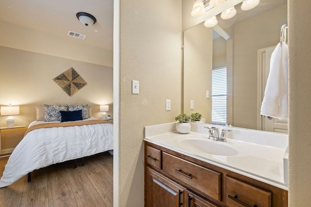 1812 Buffalo Thunder, Leander, TX 78641 - ensuite bathroom with wood finished floors, a textured wall, and vanity