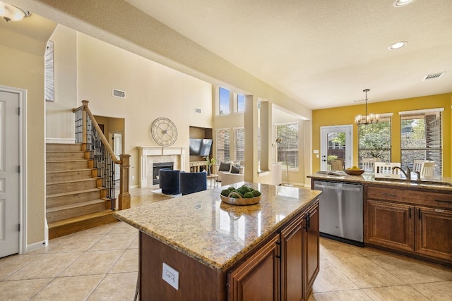 1812 Buffalo Thunder, Leander, TX 78641 - kitchen featuring stainless steel dishwasher, a fireplace, plenty of natural light, light tile patterned floors, and recessed lighting