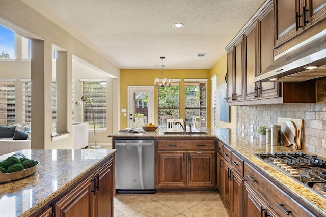 1812 Buffalo Thunder, Leander, TX 78641 - kitchen featuring appliances with stainless steel finishes, under cabinet range hood, a sink, decorative backsplash, and a chandelier