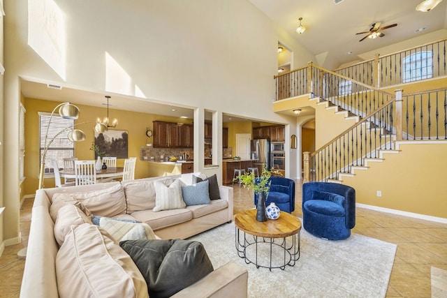 1812 Buffalo Thunder, Leander, TX 78641 - living room featuring light tile patterned floors, stairway, a ceiling fan, baseboards, and a towering ceiling