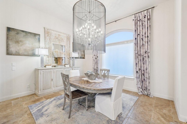 dining room with a notable chandelier and baseboards