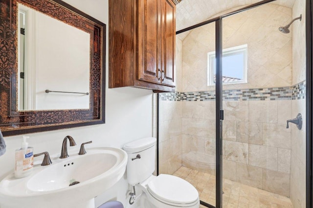 full bath with a shower stall, toilet, and a sink