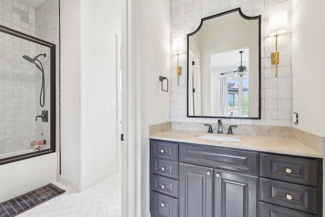 bathroom featuring combined bath / shower with glass door, vanity, and baseboards
