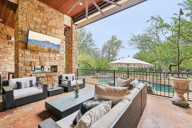 view of patio with a fenced in pool and an outdoor living space with a fireplace