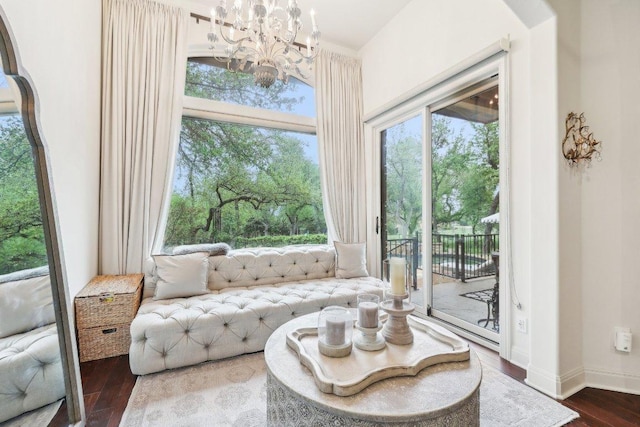 sitting room featuring baseboards, wood finished floors, and an inviting chandelier