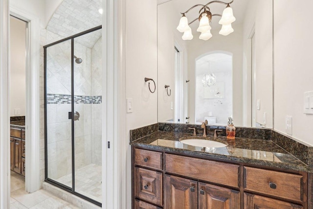 bathroom featuring an inviting chandelier, vanity, tile patterned flooring, and a stall shower