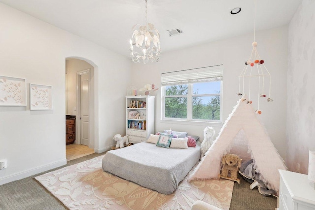 carpeted bedroom with visible vents, baseboards, a chandelier, and arched walkways