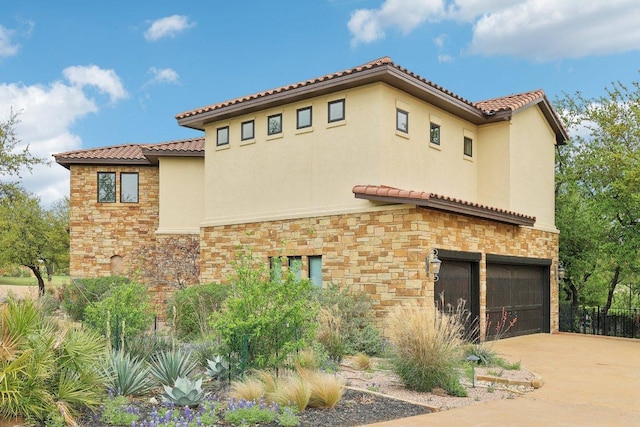 view of property exterior with stucco siding, a tile roof, an attached garage, and stone siding