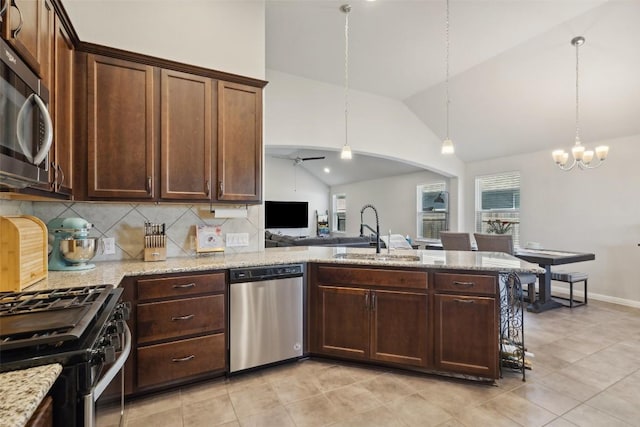 319 Silver Glen Dr, Kyle, TX 78640 - kitchen with appliances with stainless steel finishes, vaulted ceiling, a peninsula, tasteful backsplash, and light tile patterned floors
