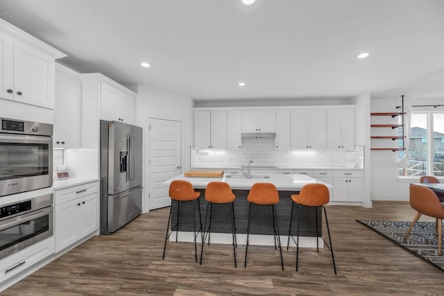 16512 Fetching Ave, Manor, TX 78653 - kitchen with stainless steel appliances, backsplash, a sink, dark wood-style floors, and white cabinetry