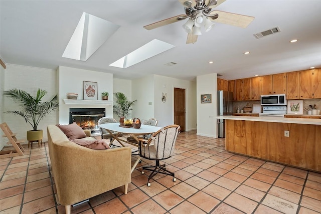 1005 Lisa Dr, Austin, TX 78733 - kitchen featuring stainless steel microwave, stove, light countertops, open floor plan, and freestanding refrigerator