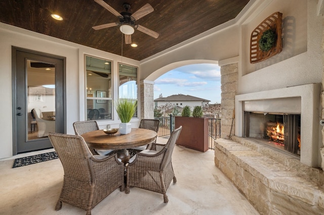 16319 Golden Top Dr, Austin, TX 78738 - view of patio with a warm lit fireplace, a ceiling fan, and outdoor dining space