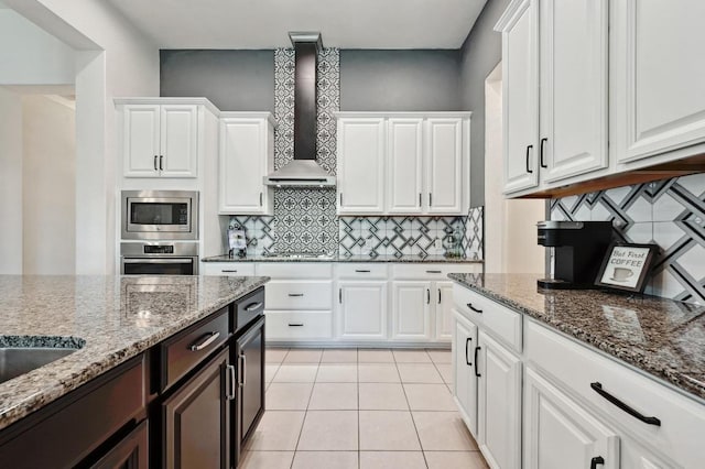 650 Ledge Stone Dr, Austin, TX 78737 - kitchen with stainless steel appliances, wall chimney range hood, white cabinetry, and backsplash