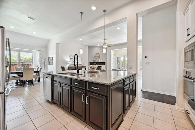 650 Ledge Stone Dr, Austin, TX 78737 - kitchen featuring a sink, stainless steel appliances, light tile patterned flooring, light stone counters, and recessed lighting