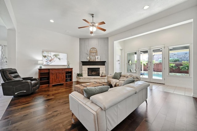 650 Ledge Stone Dr, Austin, TX 78737 - living room with wood-type flooring, a ceiling fan, french doors, a stone fireplace, and recessed lighting
