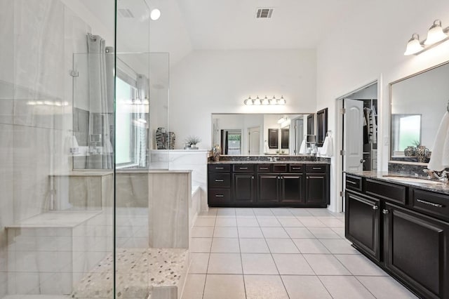 650 Ledge Stone Dr, Austin, TX 78737 - bathroom featuring a tile shower, two vanities, tile patterned flooring, a bath, and vaulted ceiling